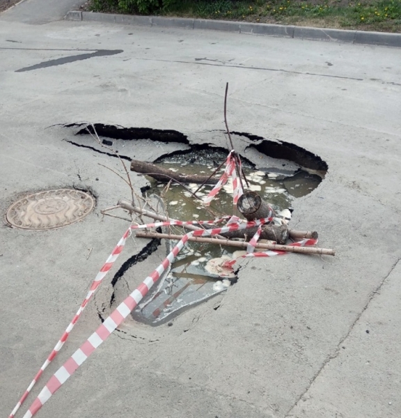 В одном из новосибирских дворов образовалась черная дыра в асфальте